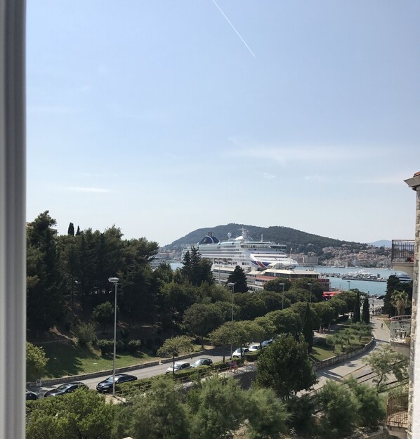 A cruise ship docked at a port with a mountainous backdrop. - Dream Luxury Rooms (Split)