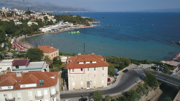 A coastal town with a beach, buildings, and a road.