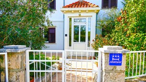 Uma entrada com portão para um edifício com uma placa indicando ser um apartamento.