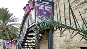 A German Colony Guest House with a stone exterior, a staircase, and wooden picnic tables. - German Colony Guest House (Haifa)