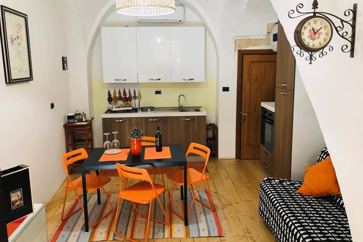 Um espaço compacto com área de refeições, cozinha e um pequeno espaço para dormir.
