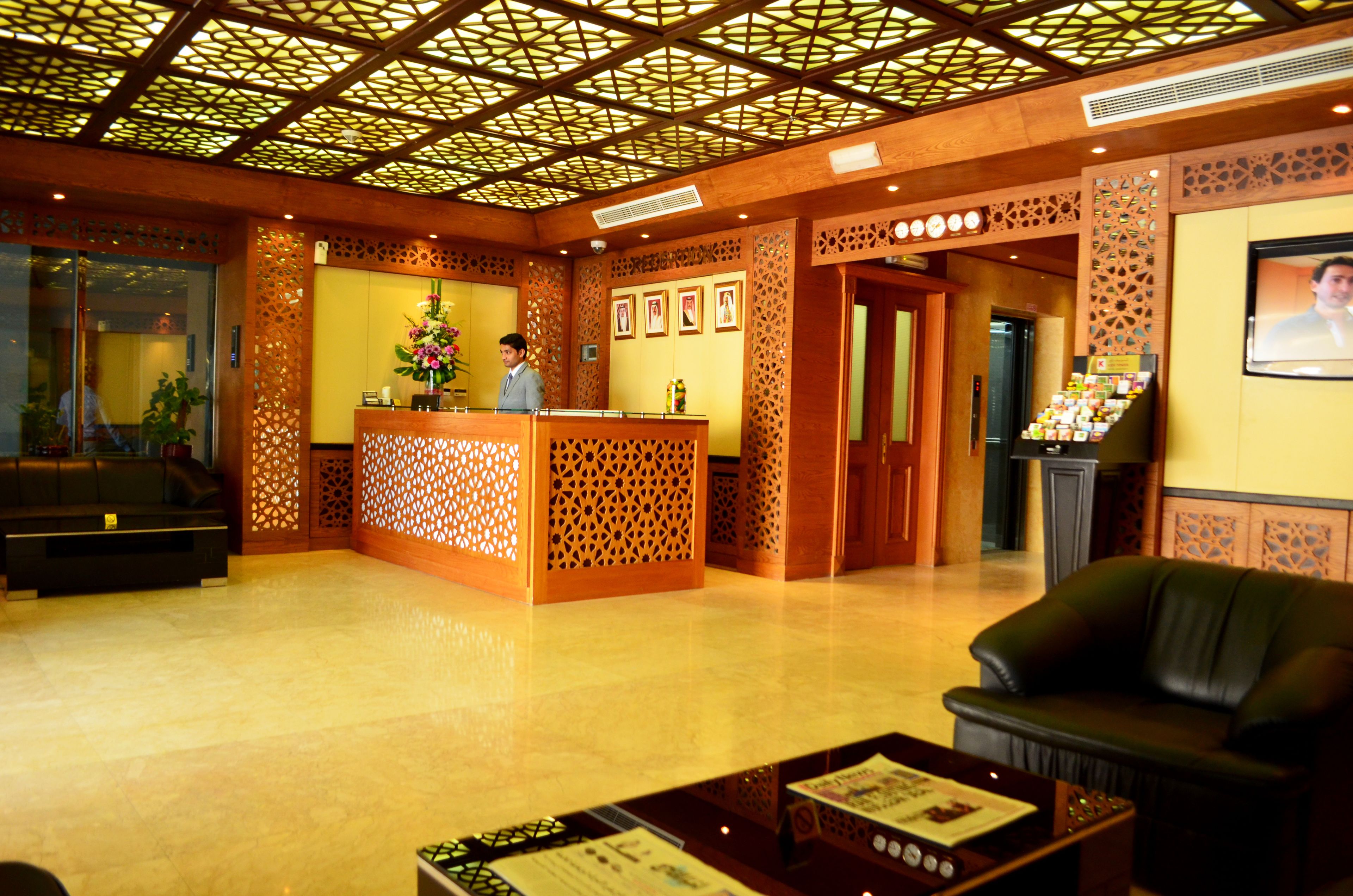 A reception area with a wooden reception desk, a black leather sofa, and a display of brochures.