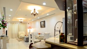 Uma sala de estar moderna com sofá, cadeiras, uma mesa de centro e um espaço de jantar com mesa e cadeiras.
