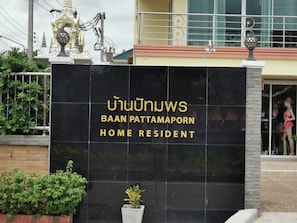 A sign for Baan Pattamaporn Home Resident with a black background and gold lettering.