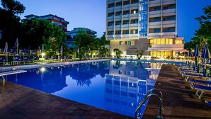 A hotel with a pool, multiple floors, and a modern design. - Hotel Ambasciatori (Cesenatico)