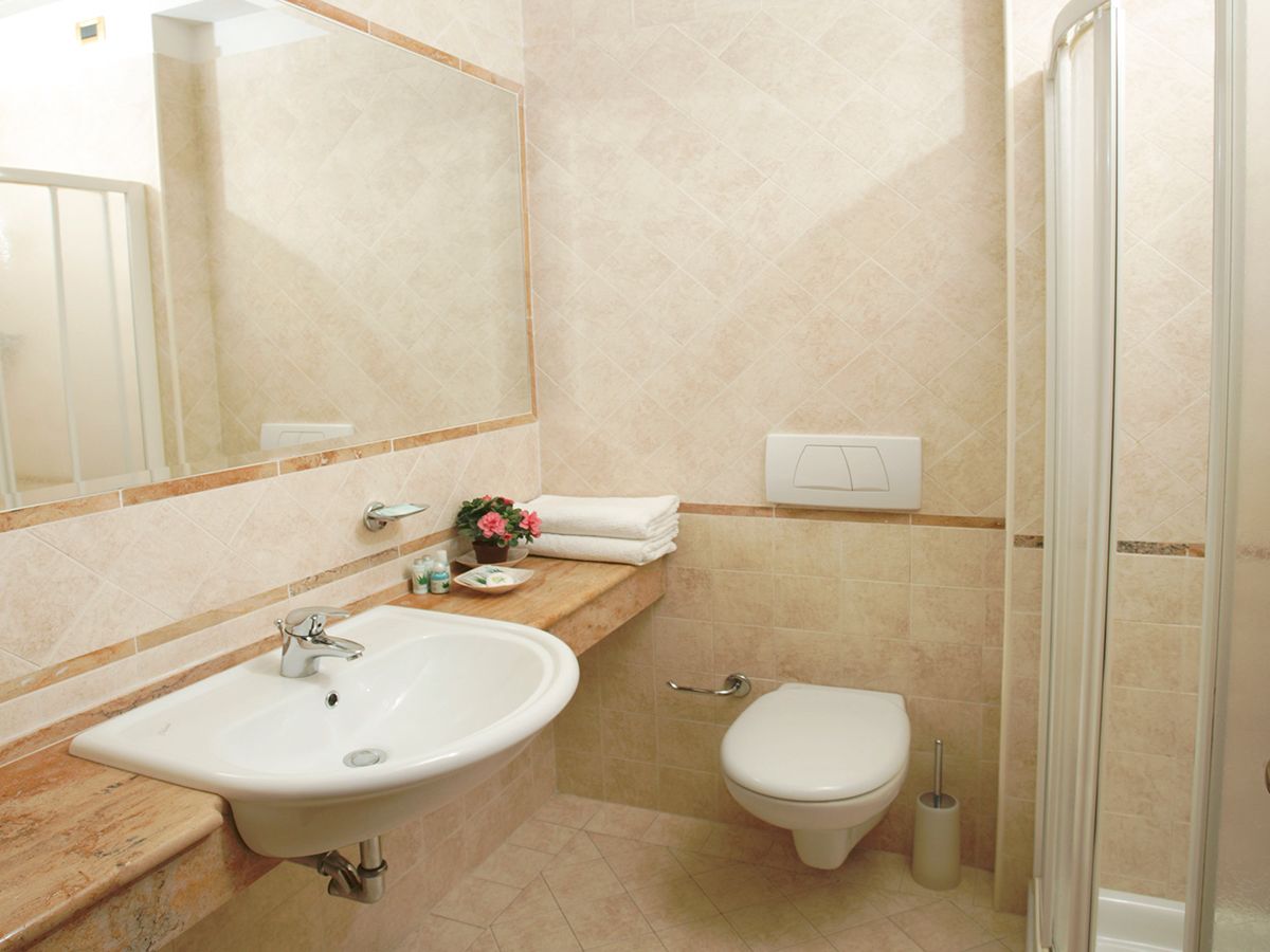 A bathroom with a sink, toilet, and shower.