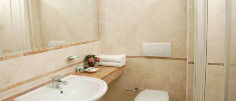 A bathroom with a sink, toilet, and shower.