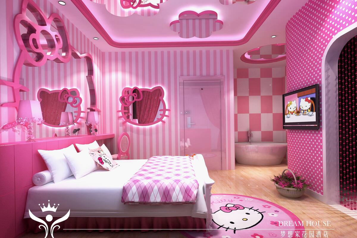 A pink-themed bedroom with a bed, a vanity with a mirror, and a television on the wall.