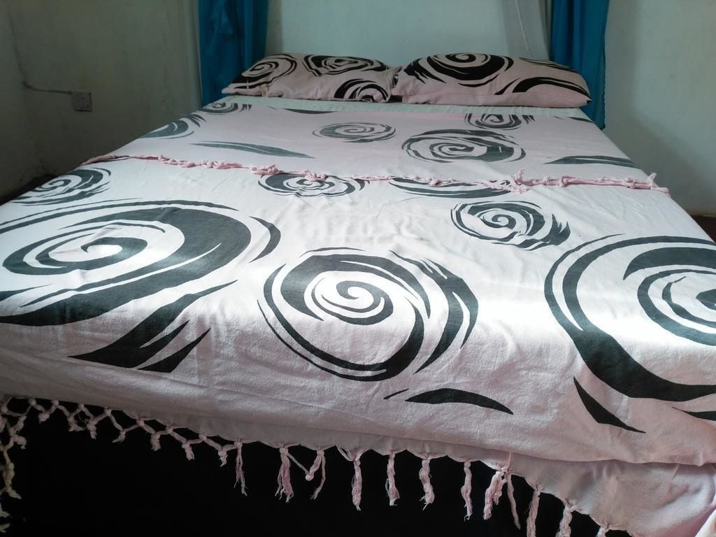 A bed with a patterned bedspread and matching pillows.