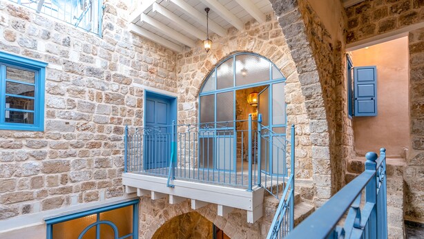 Un edificio de piedra con un balcón, una escalera y una puerta.