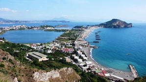A coastal town with a beach, a marina, and a mountainous backdrop. - B&B Miseno23 (Bacoli)