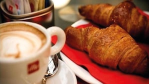 A cup of coffee and two croissants on a plate. - B&B Miseno23 (Bacoli)