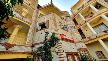A multi-story hotel with a brick facade, multiple balconies, and a sign indicating it is a hotel.