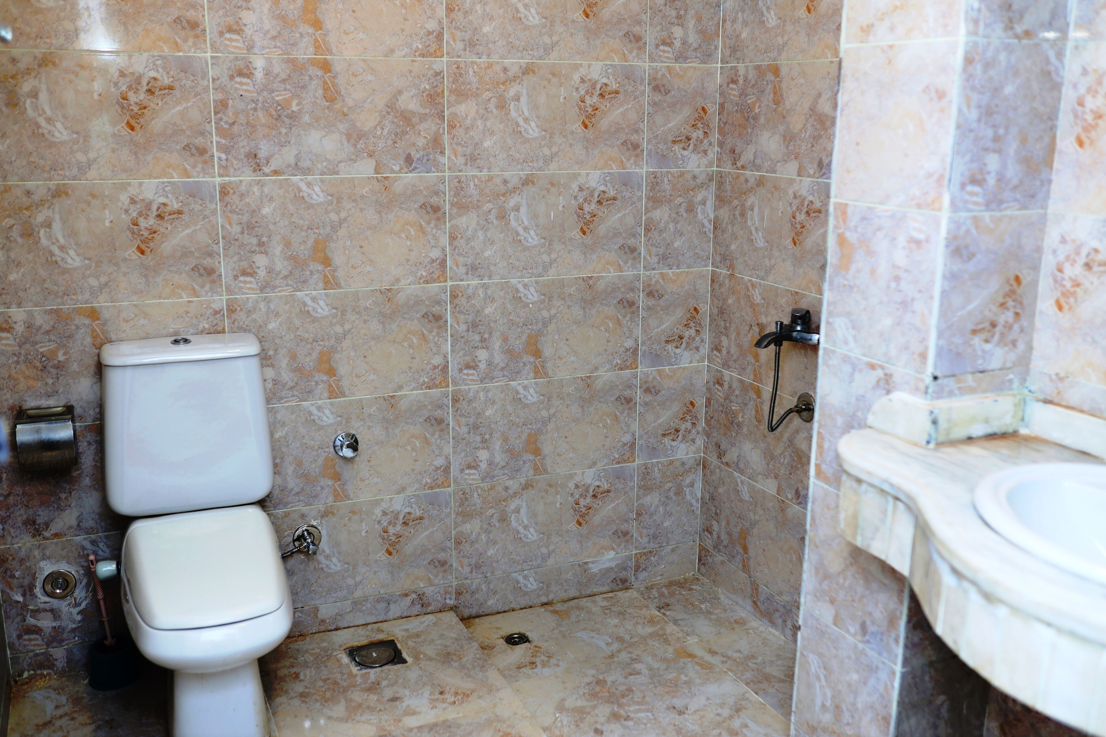 Un baño con inodoro, lavabo y zona de ducha.
