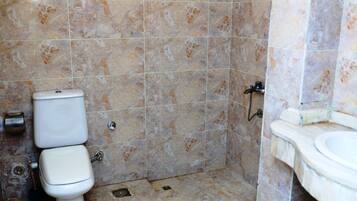 Un baño con inodoro, lavabo y zona de ducha.
