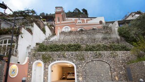A building with a stone facade, a white door, and a staircase leading to a higher level. - Il Moro di Positano (Positano)