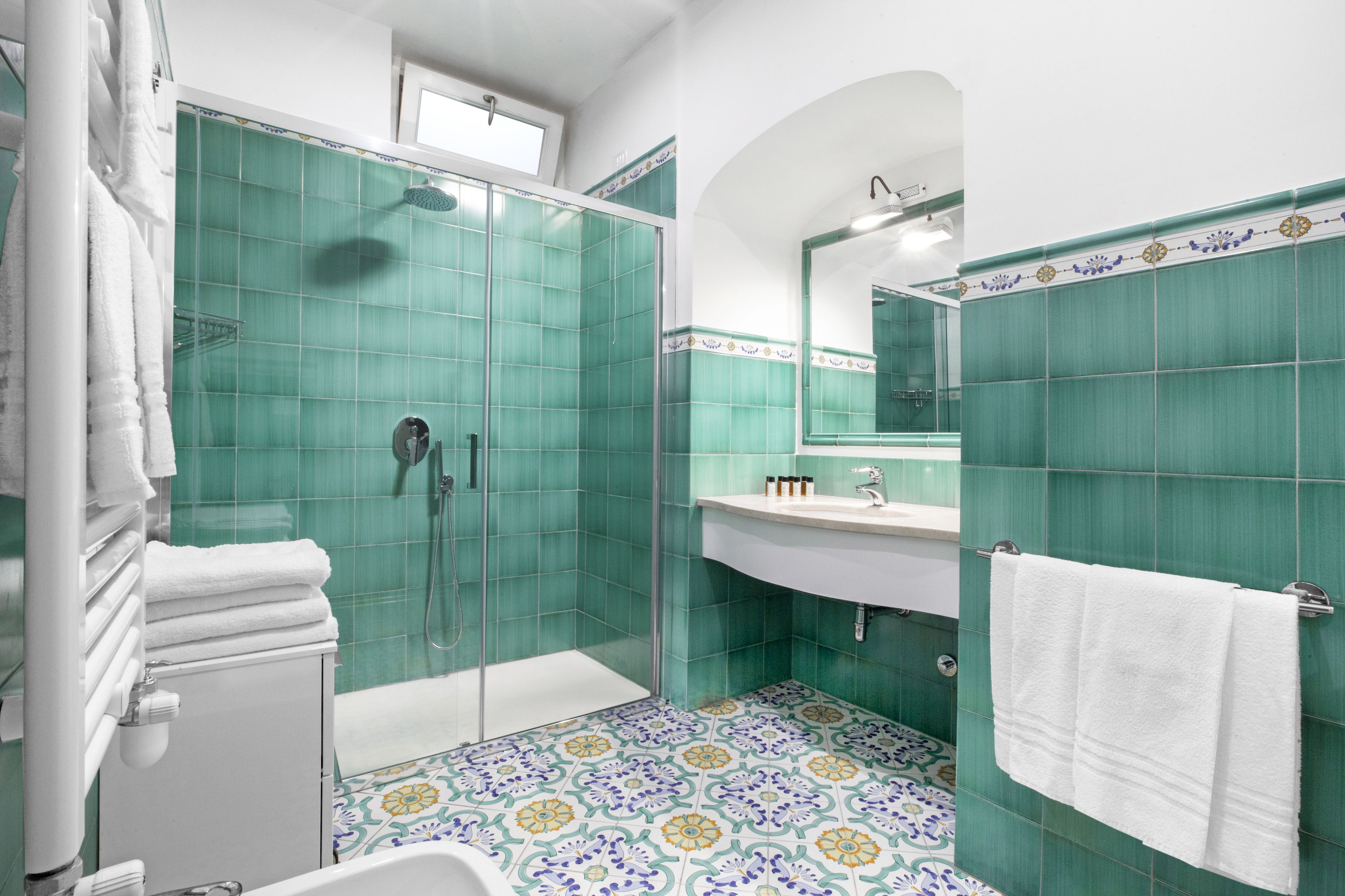 A bathroom with a shower, sink, and mirror.
