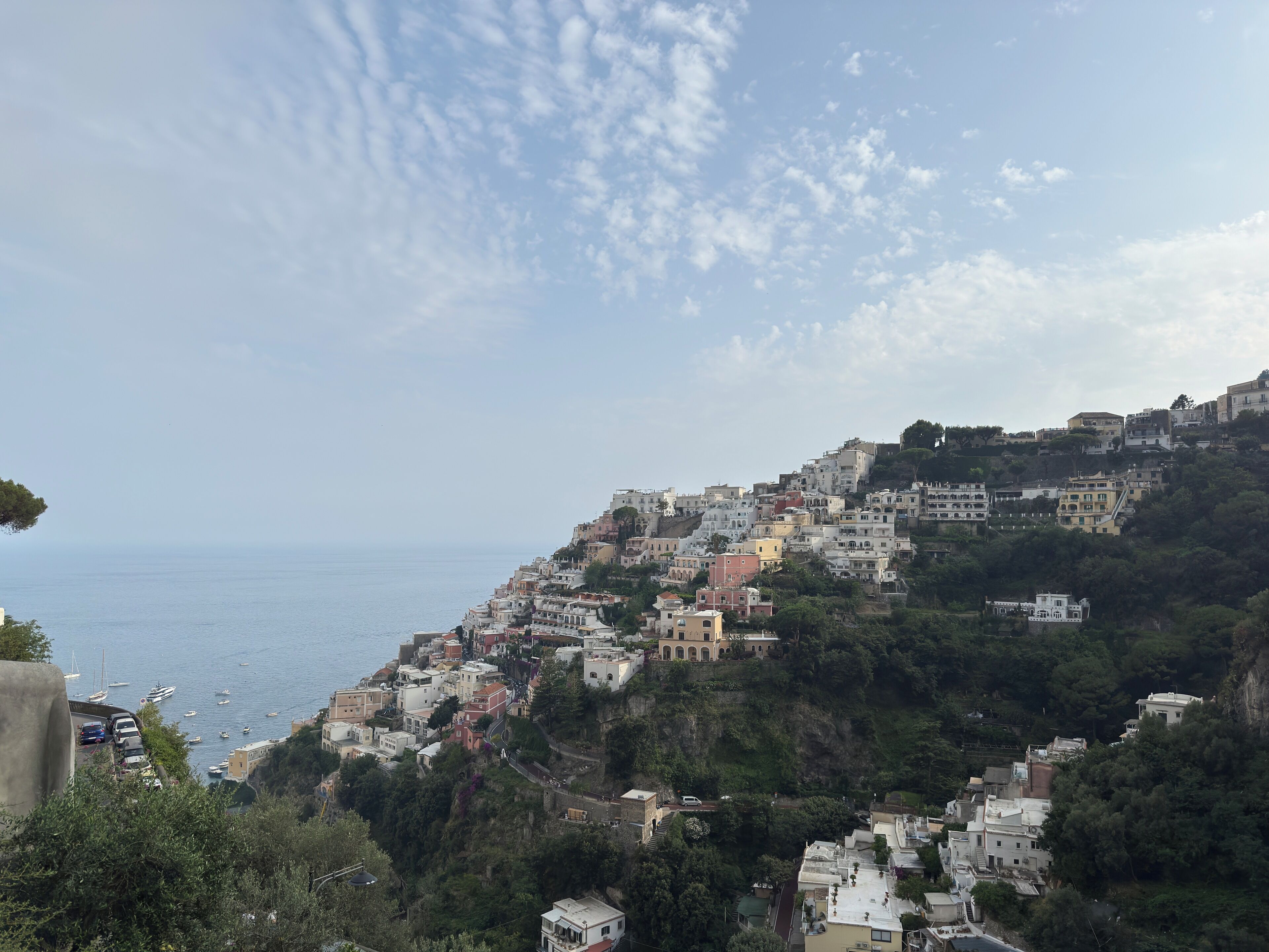 Uma vila costeira com edifícios construídos numa encosta com vista para o mar.