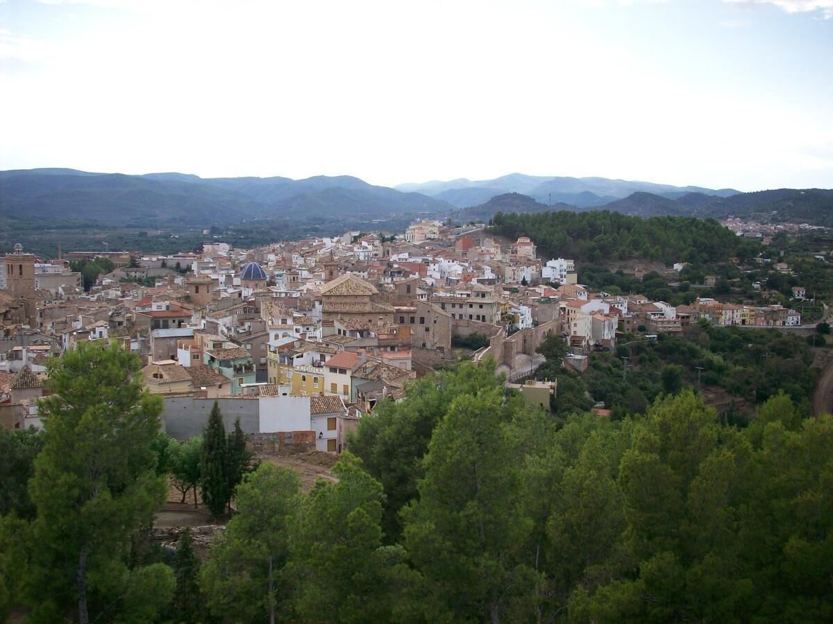 Una població densa, amb edificis històrics i un paisatge de muntanyes al fons.