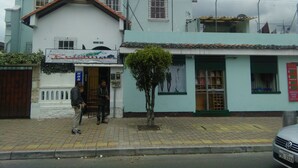 A two-story building with a sign for 'Krishna' on the ground floor. - Krishna Hostal - Hostel (Quito)