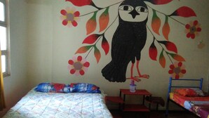 A room with a bed, a small table, and a bunk bed. - Krishna Hostal - Hostel (Quito)