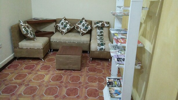 A living room with a sofa set, a coffee table, and a magazine rack. - Krishna Hostal - Hostel (Quito)