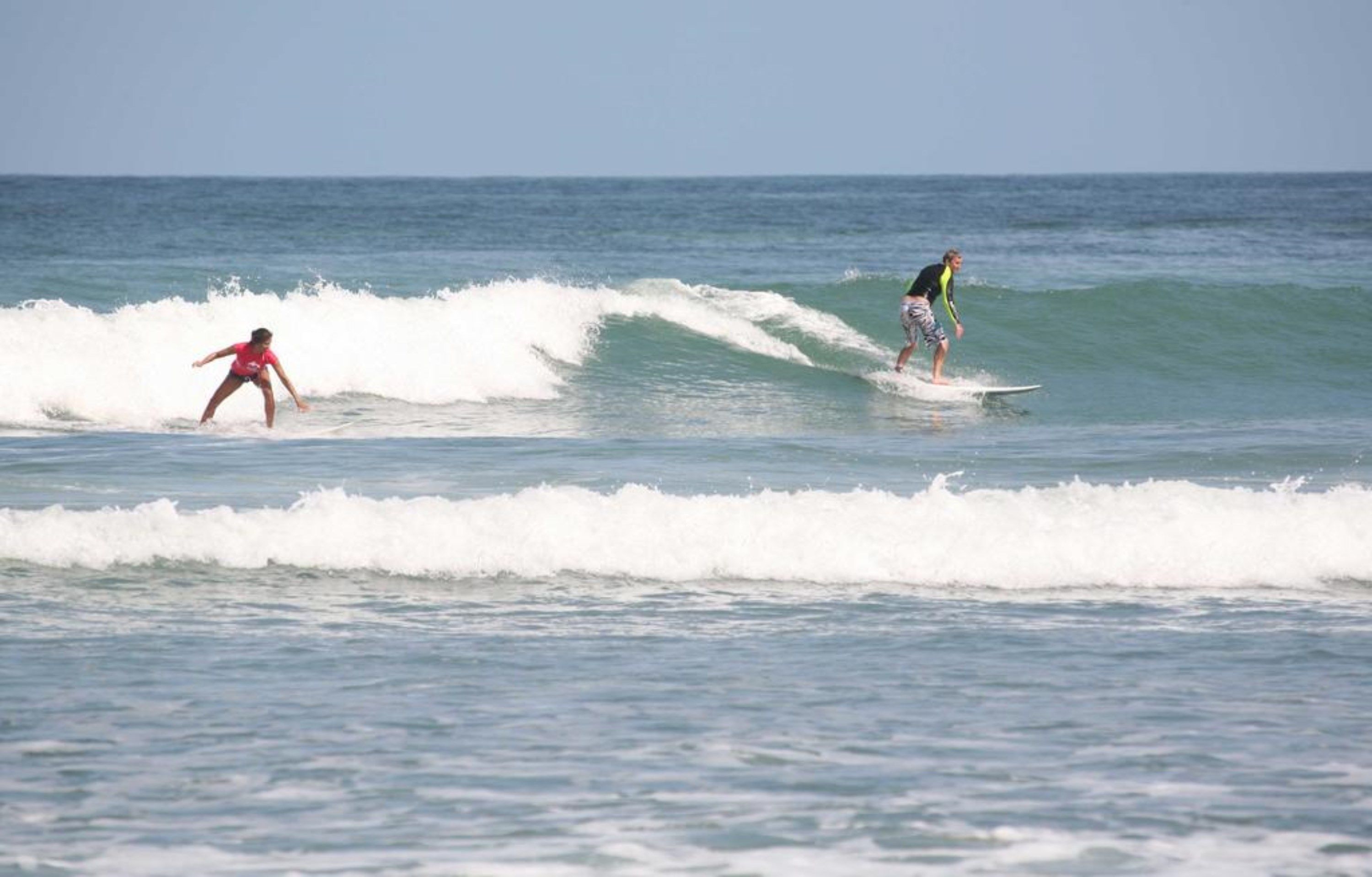 Two surfers on a wave in the ocean.