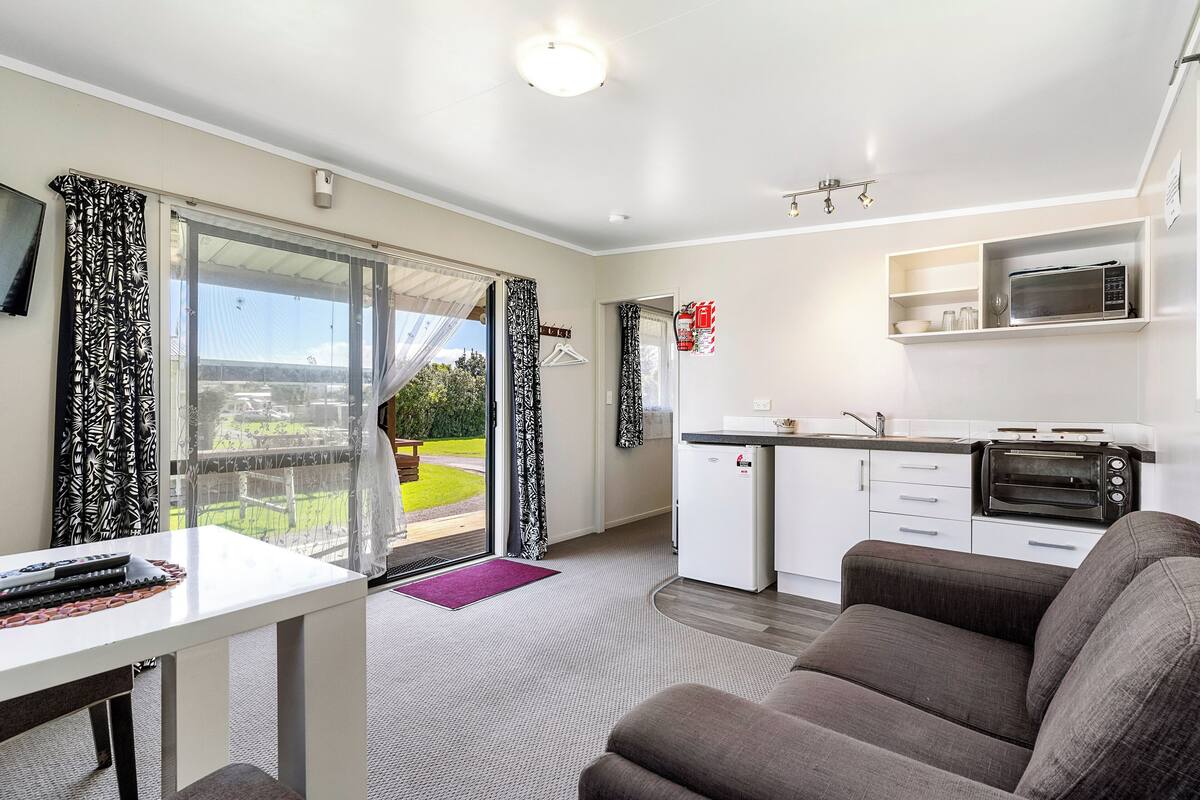 Een modern appartement met balkon, kitchenette en woonruimte.