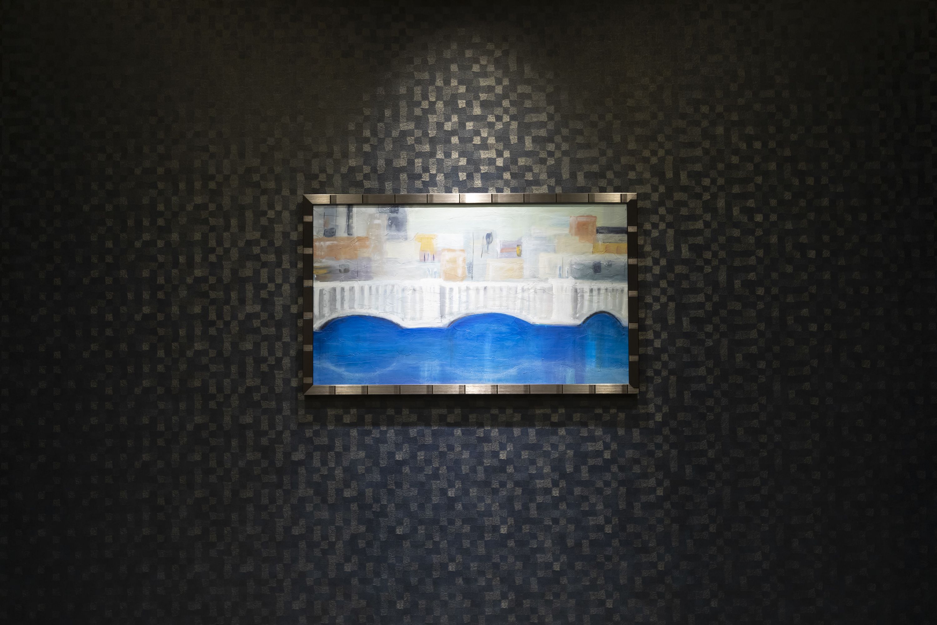 Una obra de arte enmarco sobre una pared con textura.