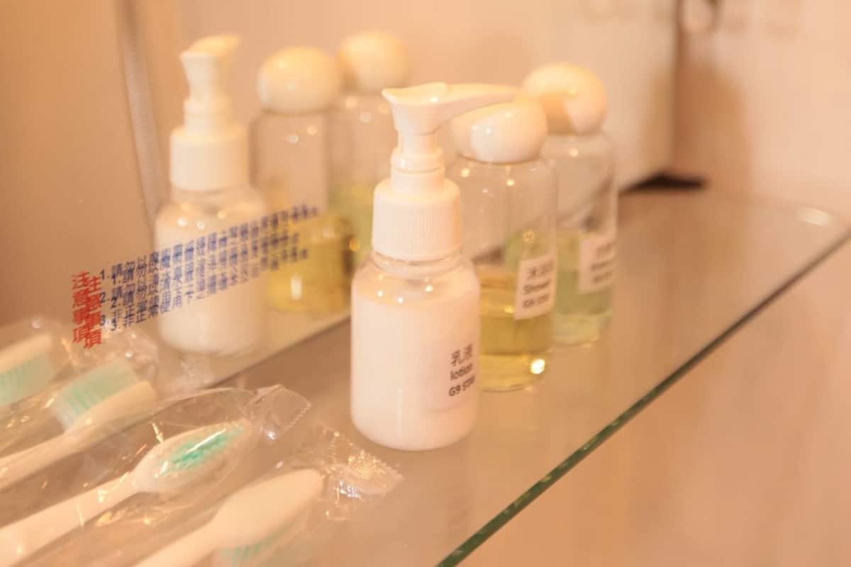 A bathroom counter with toiletries, including bottles and toothbrushes.