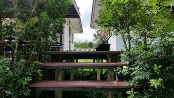 A wooden staircase leading to a covered outdoor area with potted plants.