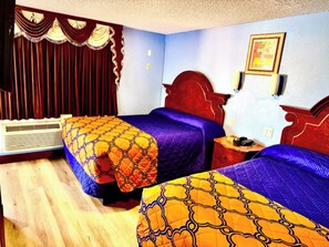 A hotel room with two beds, a red headboard, a wall-mounted picture, and a window with curtains. - A Fisher's Inn Motel (Las Vegas)