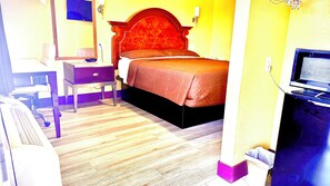 A hotel room with a bed, a desk, a chair, and a television. - A Fisher's Inn Motel (Las Vegas)
