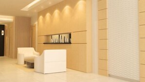 A modern hotel lobby with a reception desk, seating area, and a wall-mounted shelf with decorative items. - My Inn Hotel Lahad Datu, Sabah (LAHAD DATU)