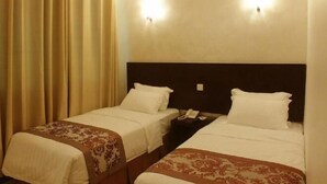 A hotel room with two single beds, each with a headboard, bedside tables, and lamps. - My Inn Hotel Lahad Datu, Sabah (LAHAD DATU)