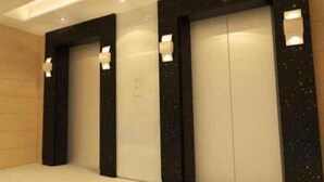 A set of three elevators with black frames and white doors, each with a small illuminated panel on the wall. - My Inn Hotel Lahad Datu, Sabah (LAHAD DATU)