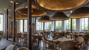 A spacious dining area with wicker furniture and large woven ceiling lamps. - Raya Heritage (Mae Rim)