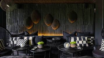 A modern interior with a sofa set, round tables, and decorative wall panels.