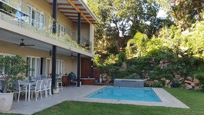 A two-story house with a balcony, a pool, and a patio area with outdoor furniture. - Umhlanga Lodge -No children (Umhlanga)