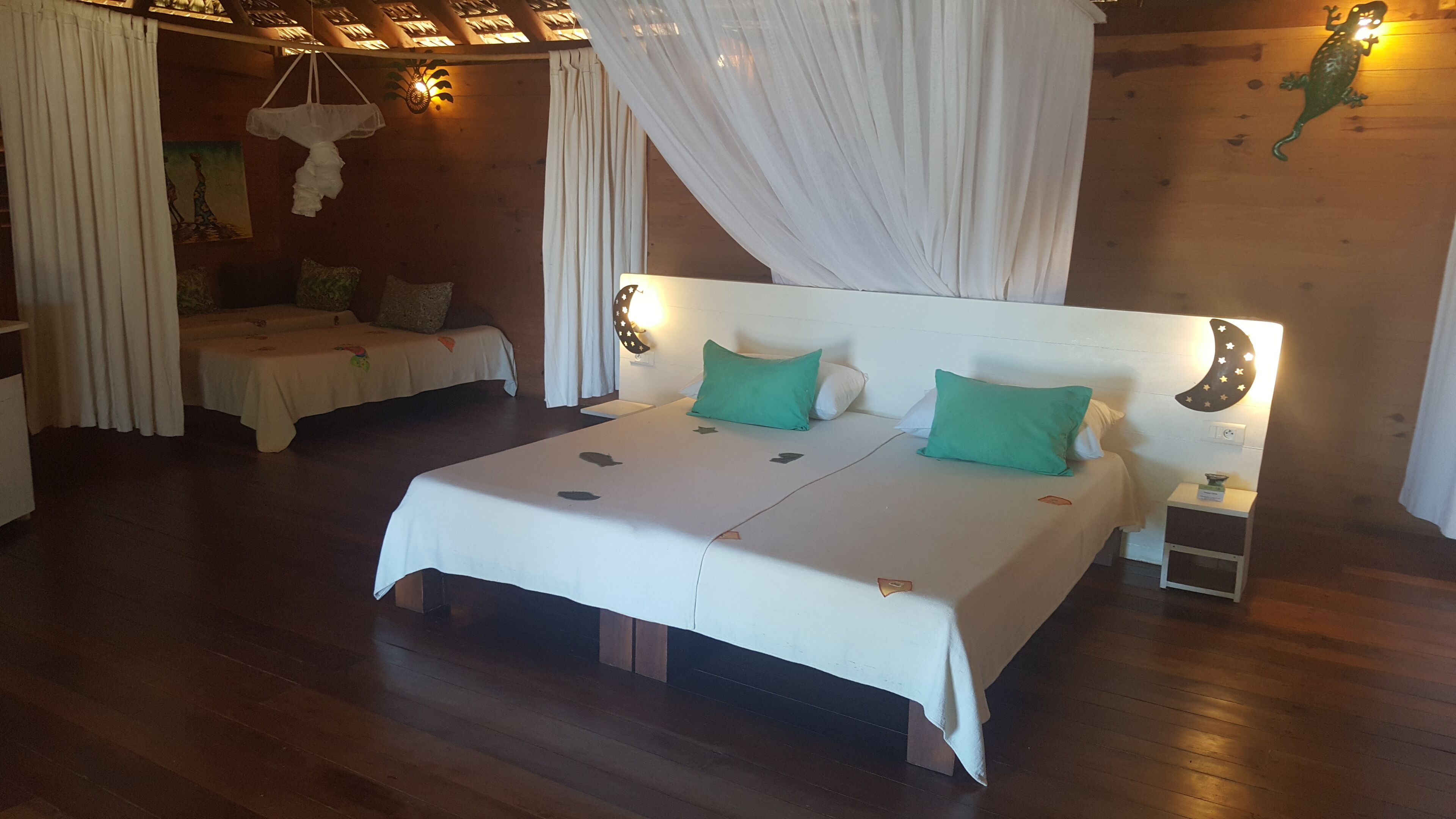 Een slaapkamer met twee bedden, een nachtkastje en decoratieve wand.