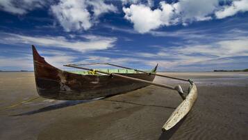 Un bote de madera en una playa arenosa bajo un cielo despejado.