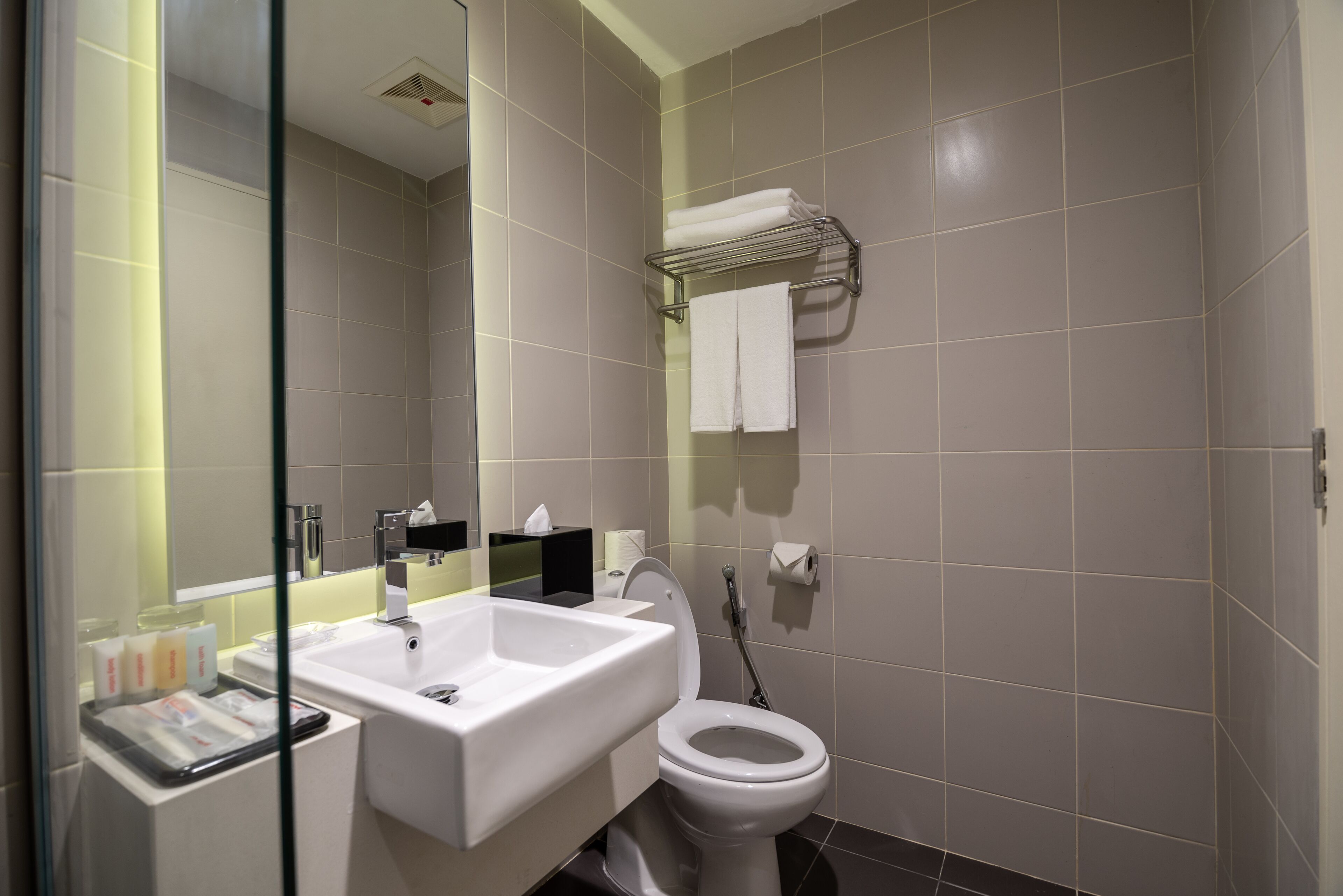 Un baño moderno con lavamanos, inodoro y cabina de ducha de vidrio.