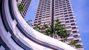 A modern building with a curved facade and multiple floors, featuring a clear sky in the background. - Ramada by Wyndham Meridin Johor Bahru (Iskandar Puteri)