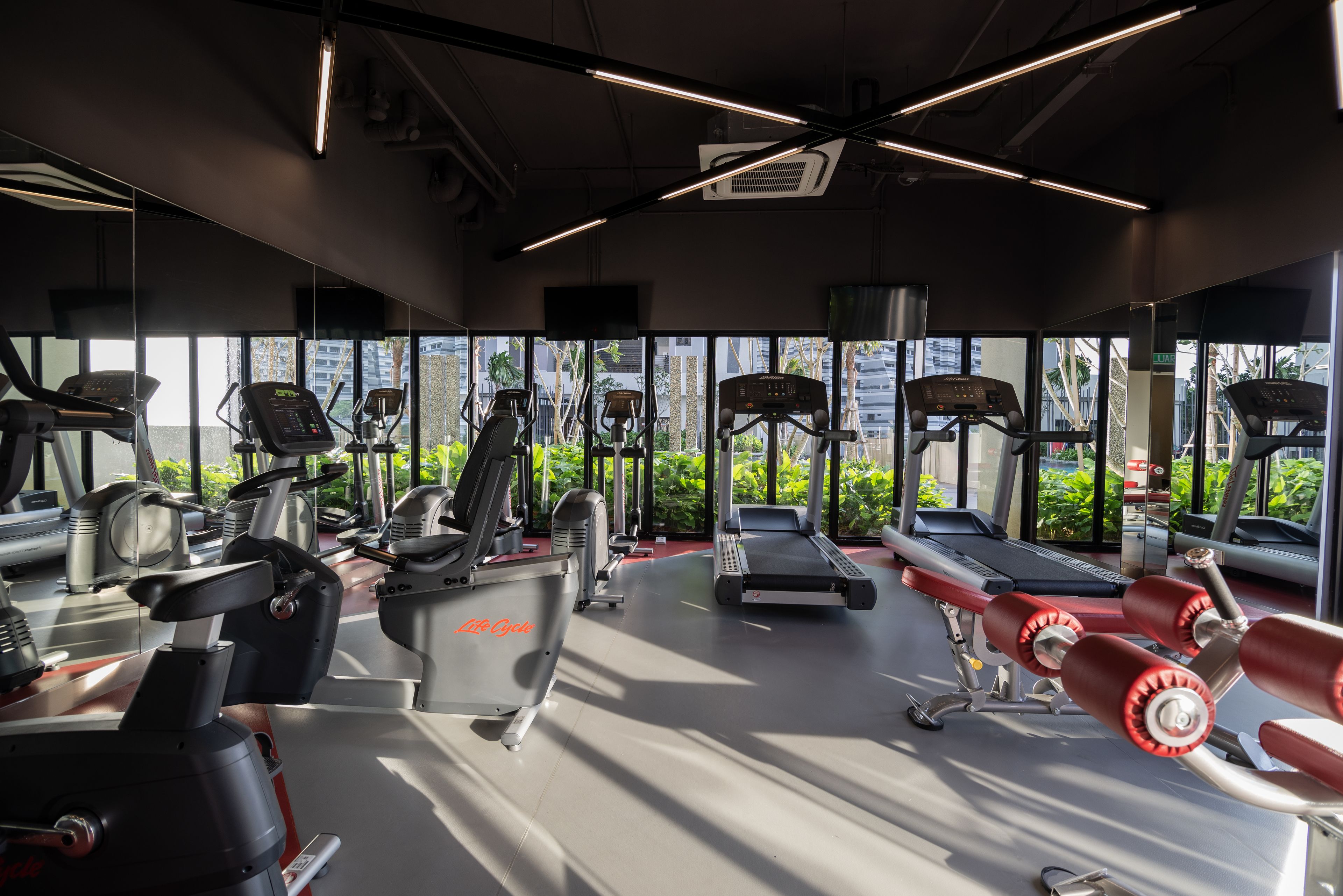 Uma academia com máquinas de cardio, equipamentos de musculação e esteira.