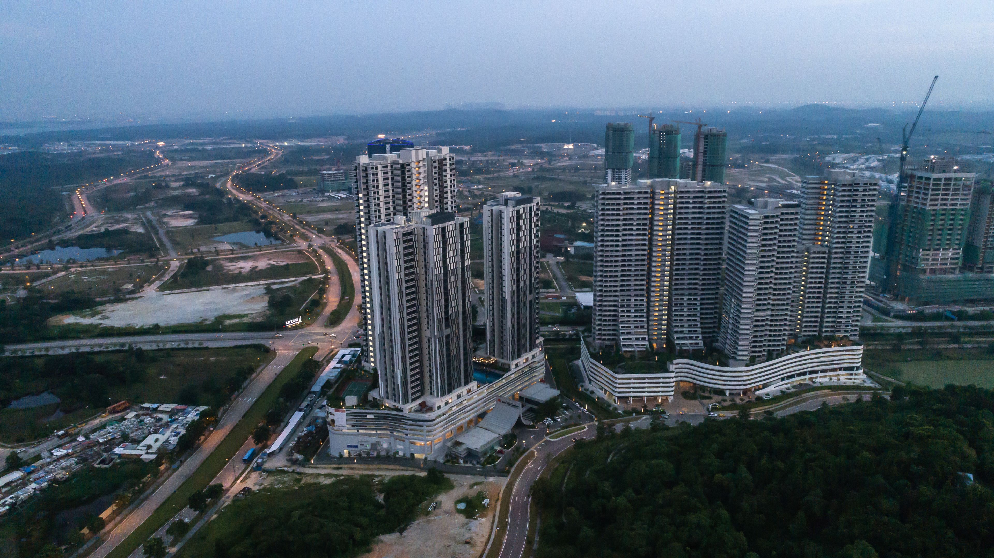 Un ensemble immobilier composé d’immeubles de grande hauteur, dont plusieurs gratte-ciel, ainsi que de routes et d’espaces verts environnants.