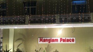 A building facade with a sign reading "Manglam Palace" and several potted plants arranged in front. - Hotel Mangalam Palace - Lucknow Airport (Lucknow)