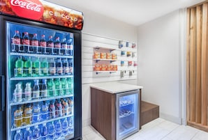 Zona de máquinas expendedoras con diversas opciones de bebidas, incluyendo Coca-Cola, Sprite y Powerade.