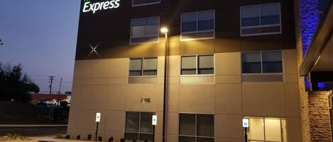 A Holiday Inn Express building with a modern design, multiple windows, and a parking lot with handicapped parking spaces.