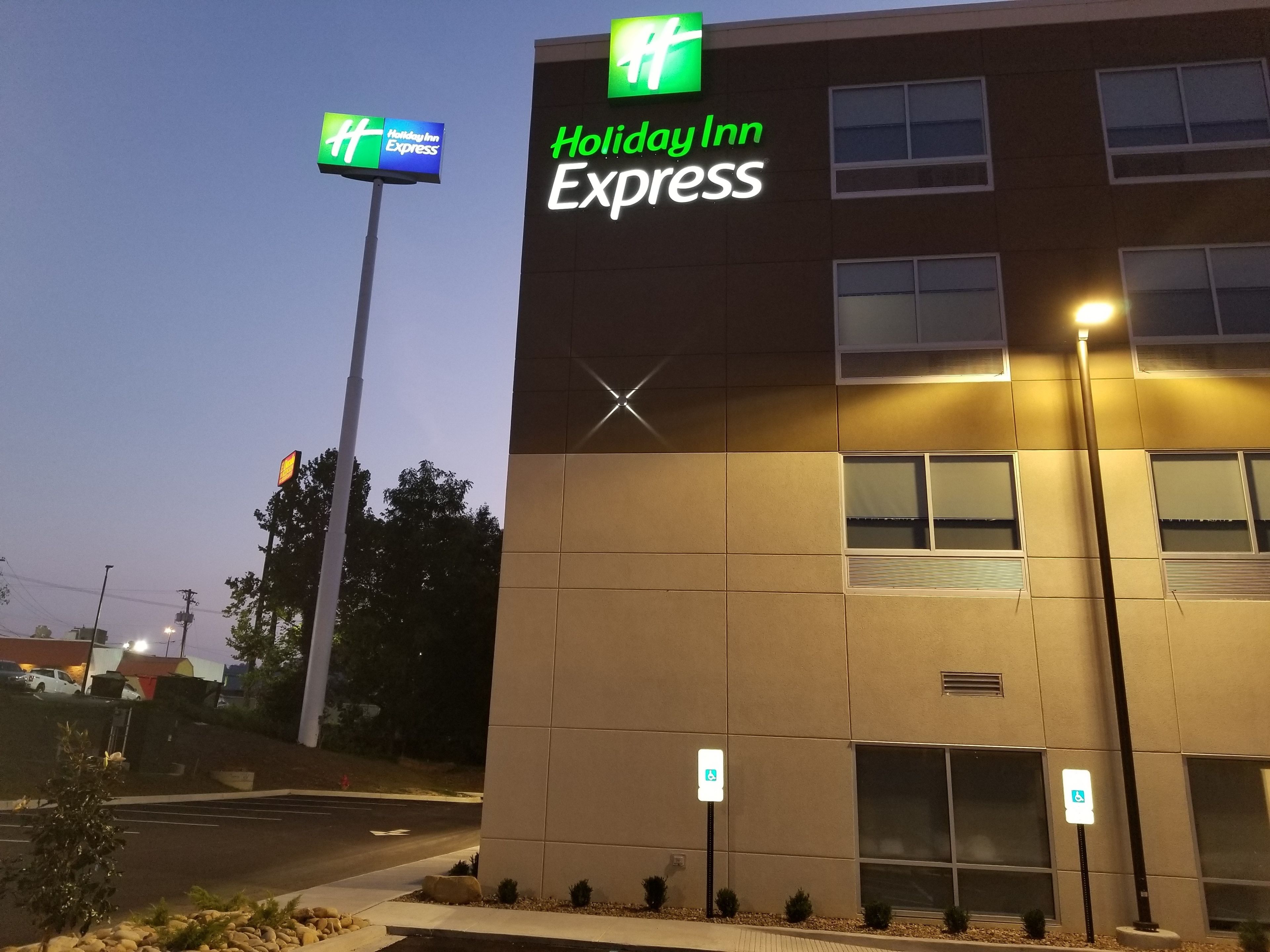A Holiday Inn Express building with a modern design, featuring a prominent sign and accessible parking.