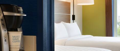 A hotel room with a coffee machine, a bed, and a window with a view.